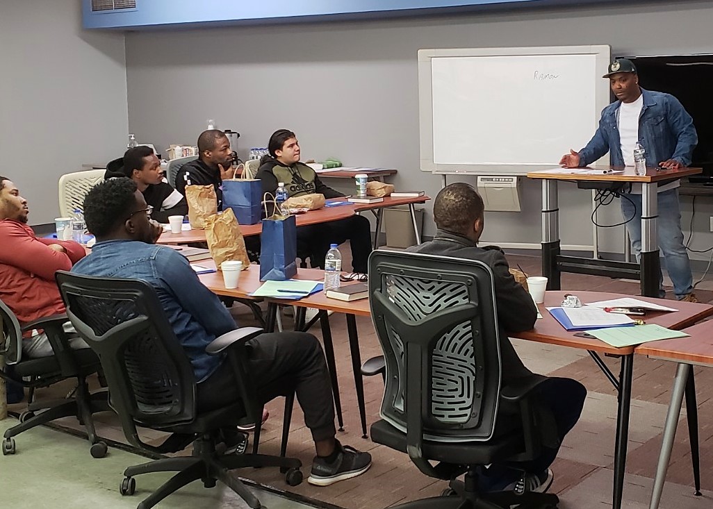 man speaking with other men at enrichment workshop