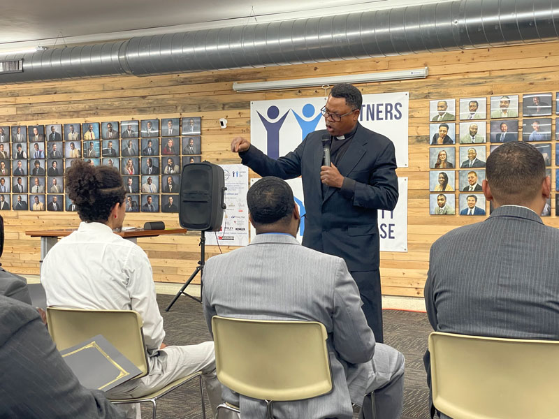 preacher giving the good news to a group of men graduating from the program