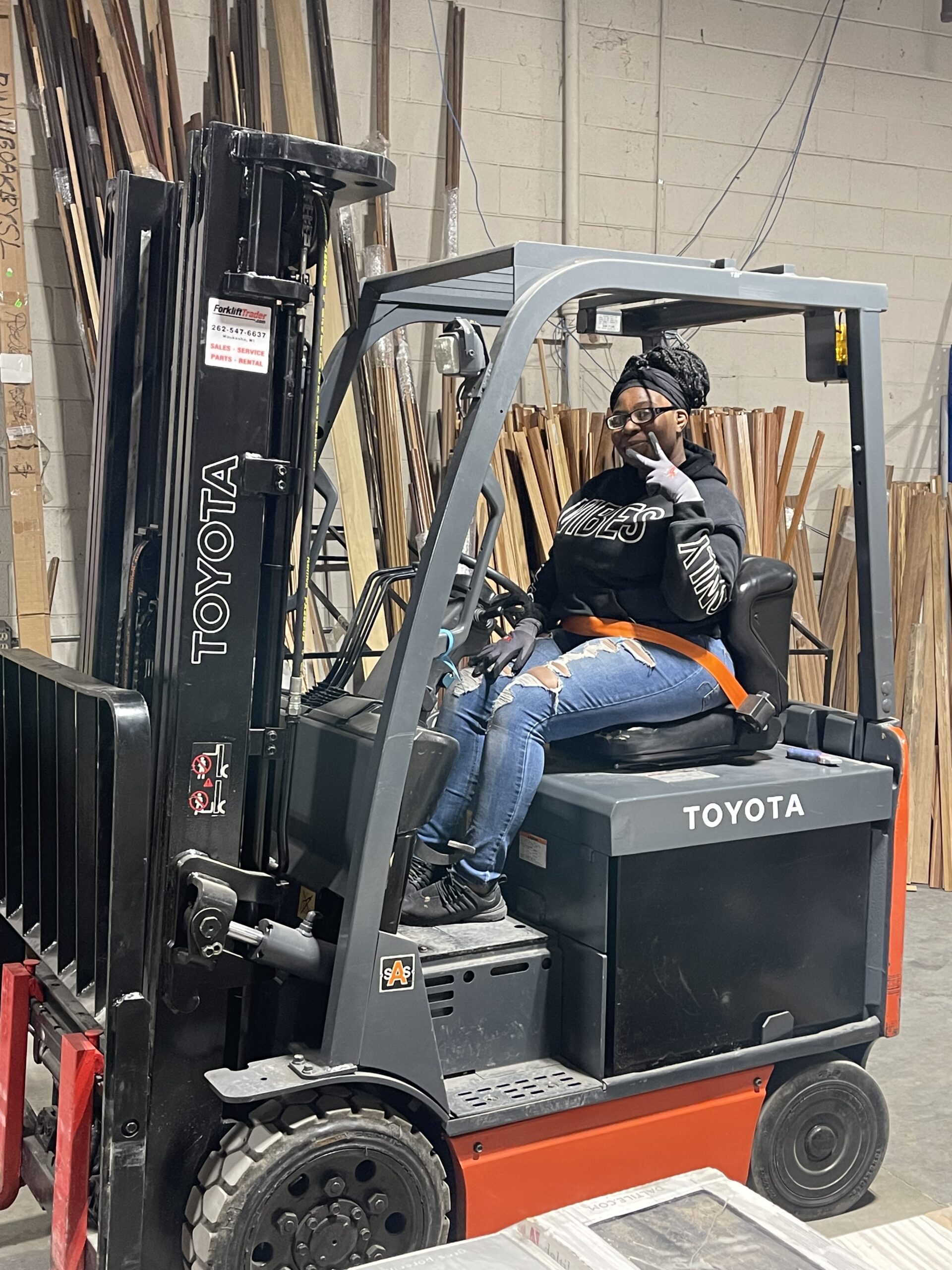 young lady driving a forklift peace sign